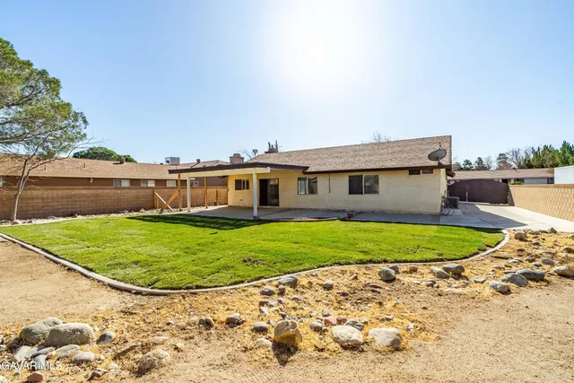 a view of a white house with a swimming pool and a yard