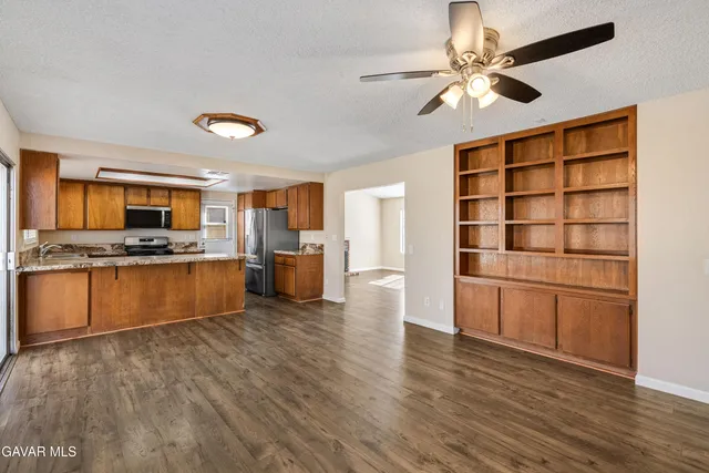 a kitchen with stainless steel appliances kitchen island granite countertop a stove cabinets and wooden floor
