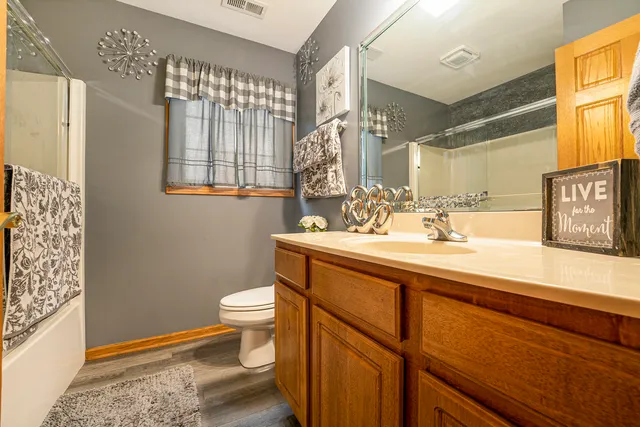 a bathroom with a sink a toilet a mirror and shower