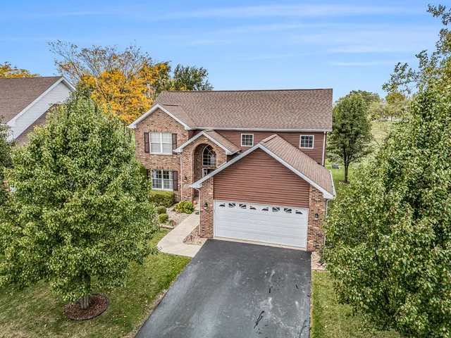 a view of a house with a yard and large trees