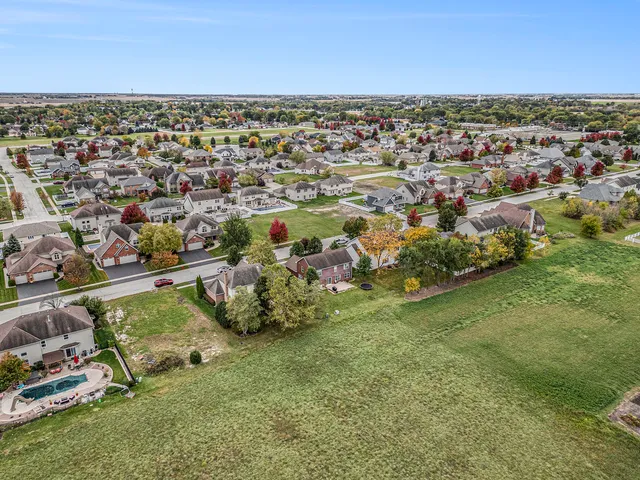 an aerial view of residential houses with outdoor space and trees