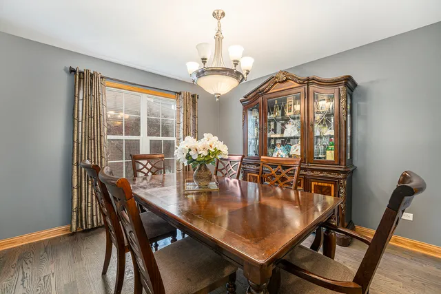 a dining room with furniture a chandelier and wooden floor