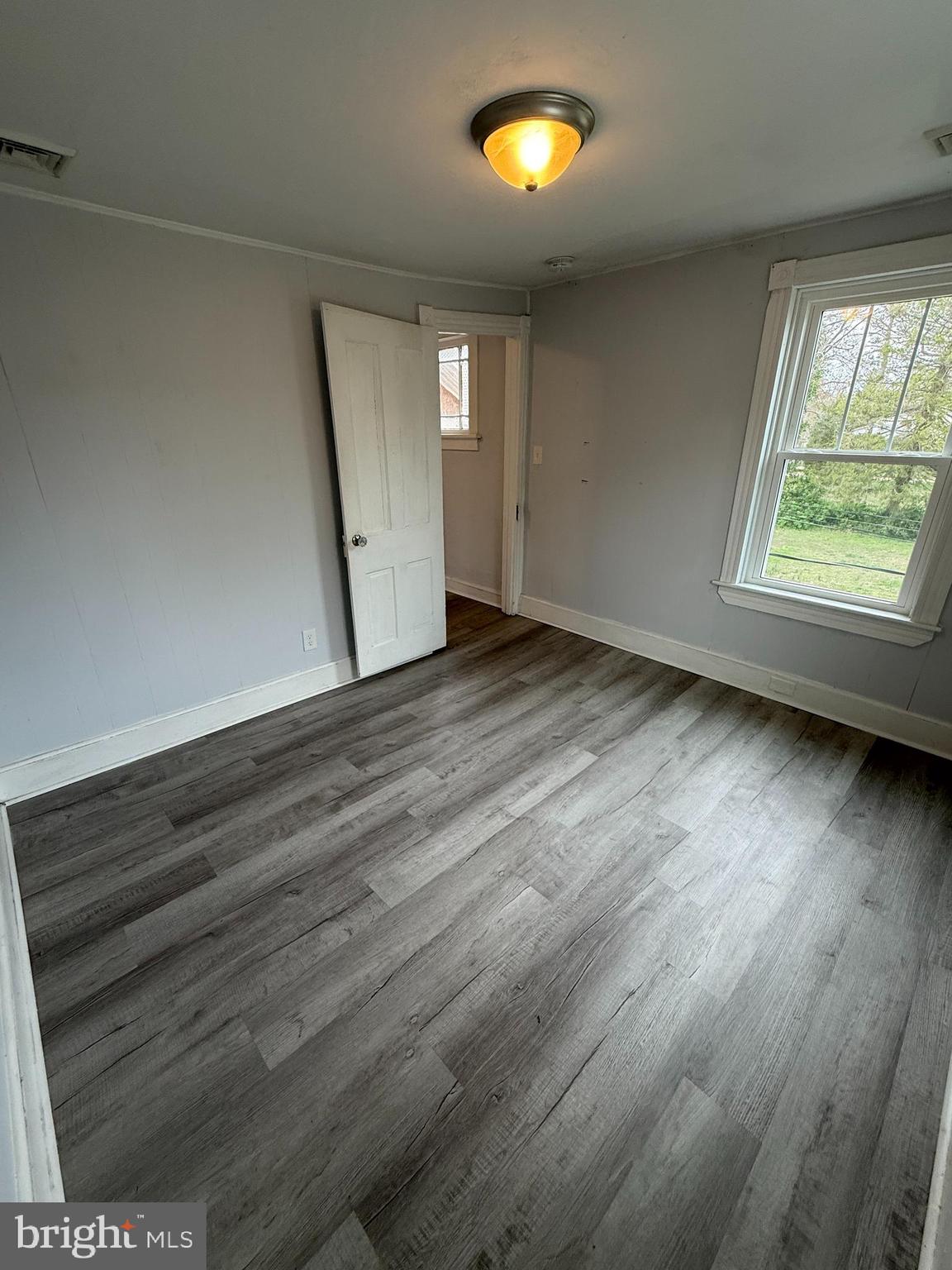 1036 South Spring Road Vineland, NJ 08361 - Photo 25 of 31 an empty room with wooden floor and windows
