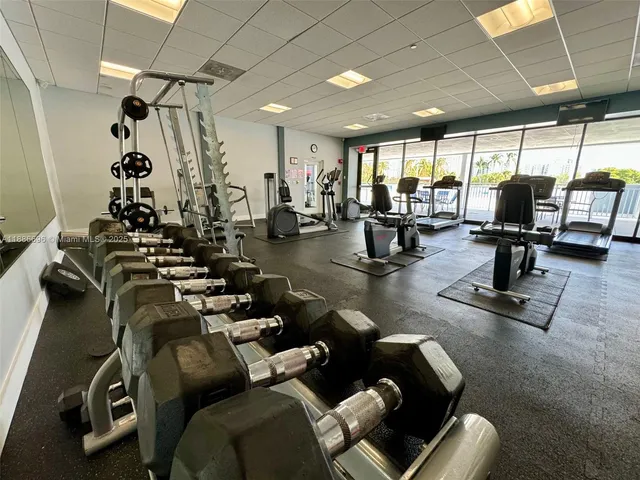 a living room with furniture gym equipment and a large window