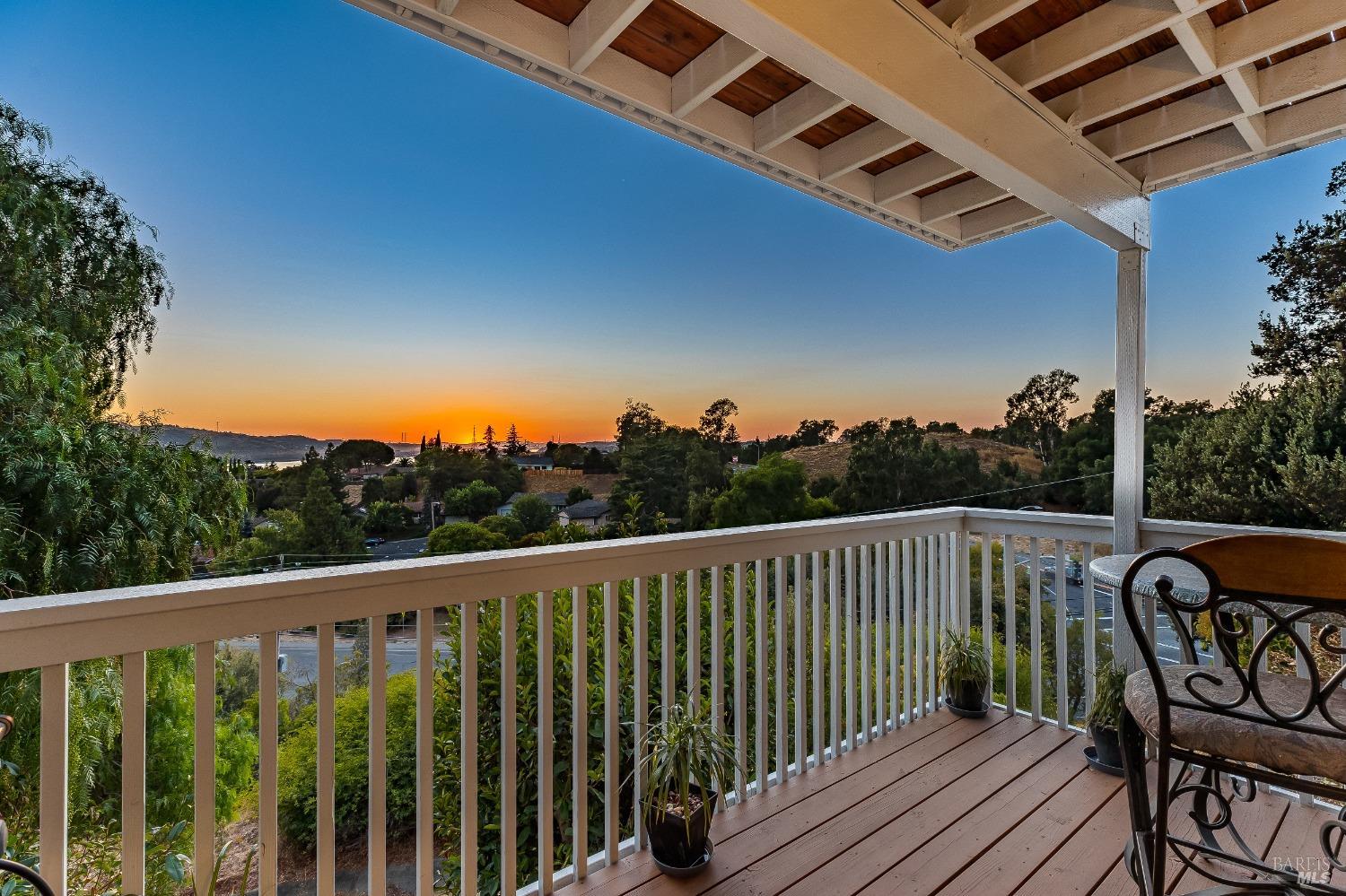 a view of a balcony with wooden floor and outdoor seating