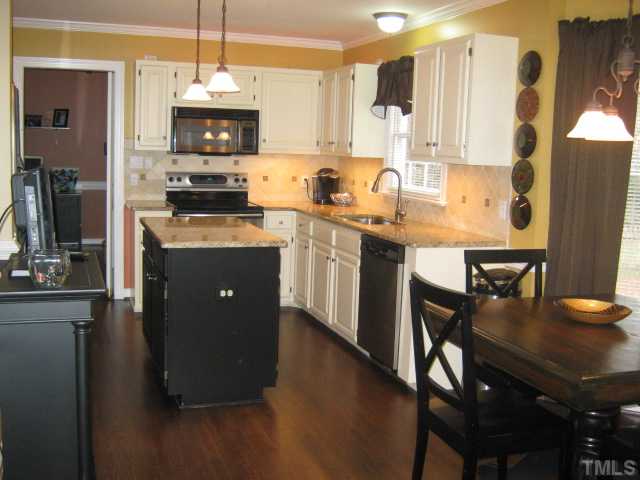 9117 Doublebit Drive Raleigh, NC 27615 - Photo 11 of 12 Another view of updated kitchen featuring newly refinished hardwoods, tile backsplash, granite countertops, stainless steel appliances, great kitchen island with electrical outlets makes for extra space when cooking and baking, or use for serving from!