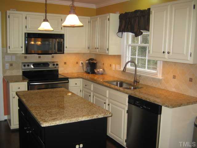 Tastefully redone kitchen with granite countertops, island, tile backsplash, stainless undermount sink, stainless appliances, newly refinished hardwoods, built-in microwave, under cabinet lighting for nice pools of light to show off your granite!