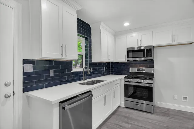 a kitchen with a sink stove and microwave