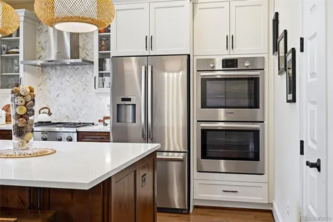 a kitchen with stainless steel appliances a stove refrigerator and microwave