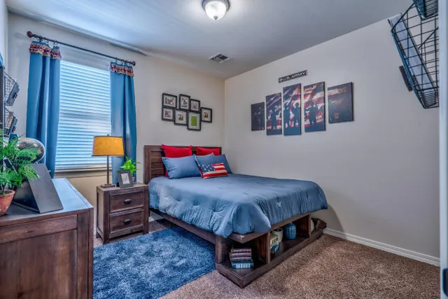 a bedroom with a bed painting on wall and a potted plant