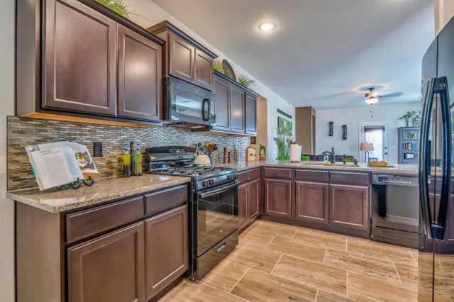 a kitchen with stainless steel appliances granite countertop a stove sink and cabinets