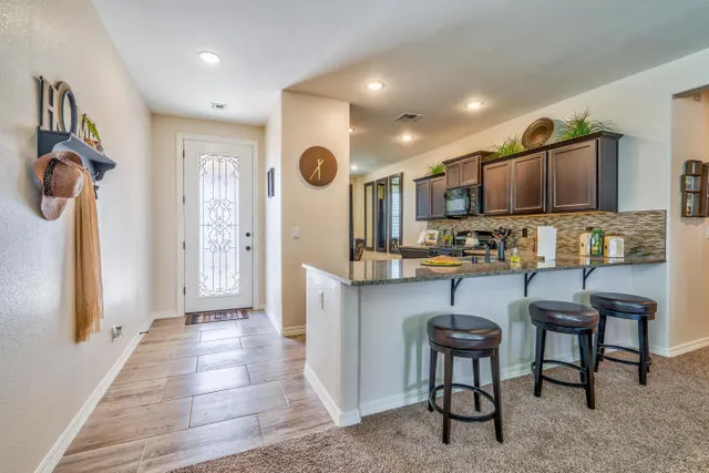 a kitchen with stainless steel appliances kitchen island granite countertop a refrigerator and a stove top oven