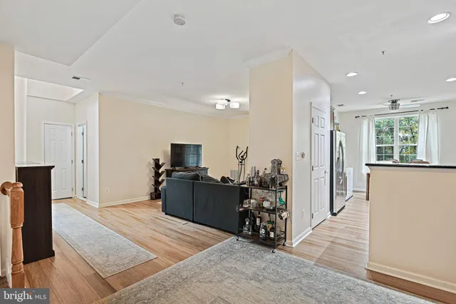 a living room with stainless steel appliances furniture a fireplace and a flat screen tv