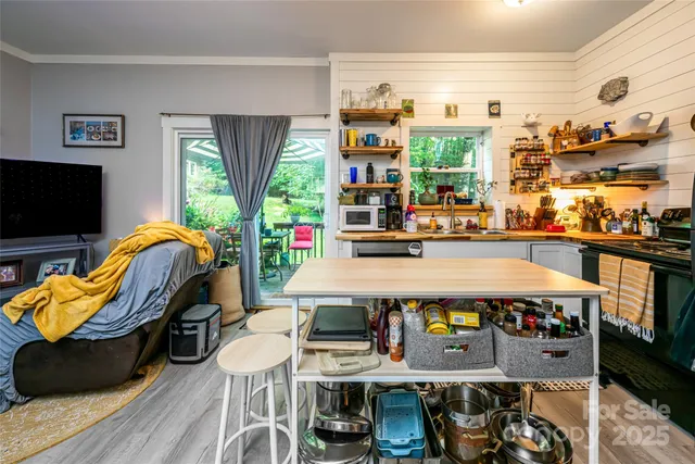 a living room with furniture a flat screen tv and floor to ceiling window