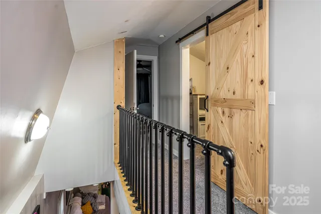 a view of a hallway with wooden floor and staircase