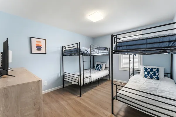 a bedroom with a bed and a flat tv screen on the dresser