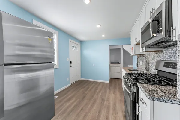 a kitchen with stainless steel appliances granite countertop a stove and a refrigerator