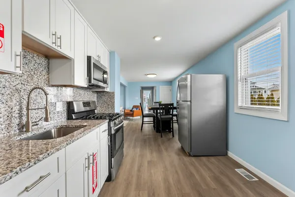 a kitchen with stainless steel appliances granite countertop a refrigerator stove and sink