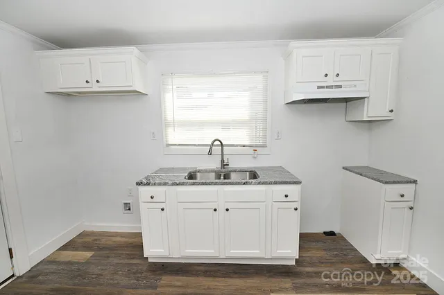 a view of cabinets a sink and a stove in a kitchen