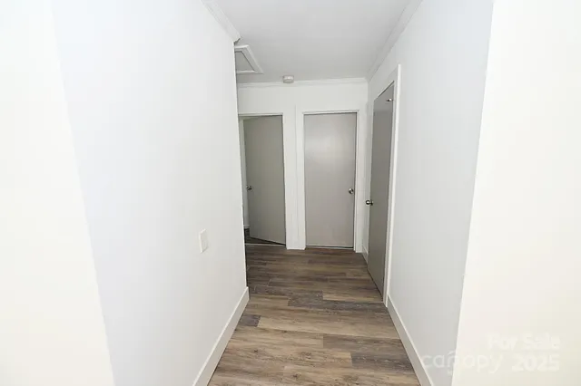 a view of a hallway with wooden floor