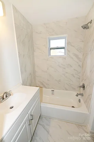 a bathroom with a bathtub a sink and a window