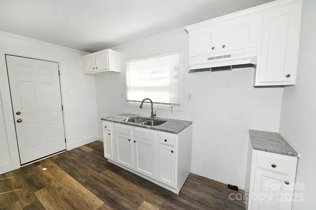 a kitchen with cabinets appliances and a wooden floor