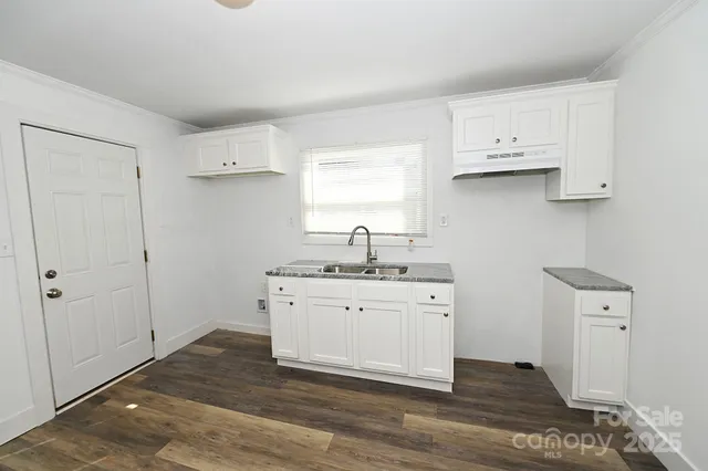 a kitchen with a sink cabinets and a window