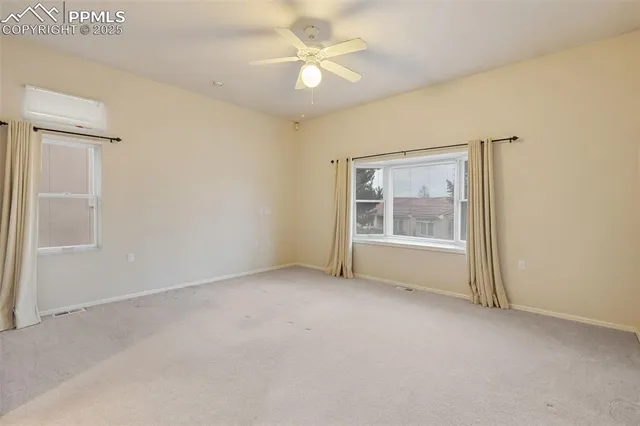 an empty room with a window and a ceiling fan
