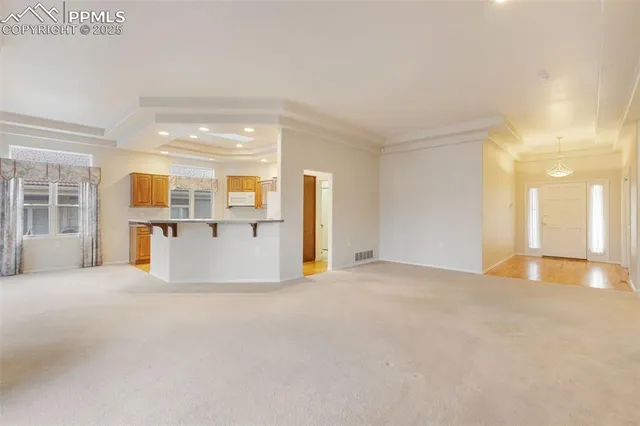 a view of empty room with kitchen and window