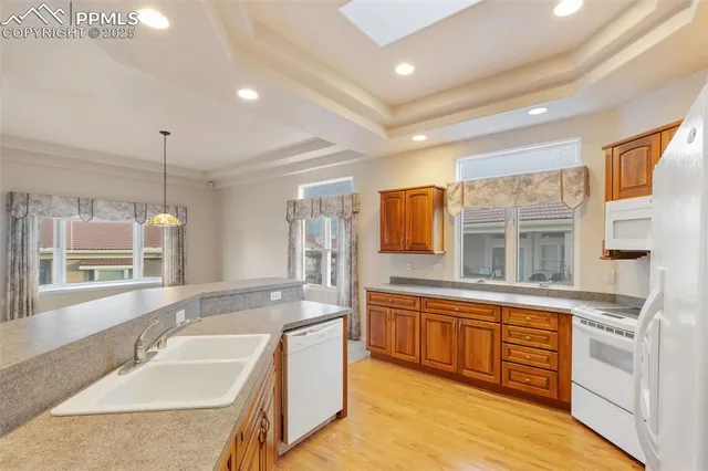 a large kitchen with kitchen island a large window and stainless steel appliances