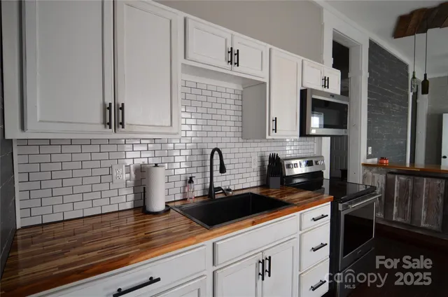 a kitchen with granite countertop a sink stove and cabinets
