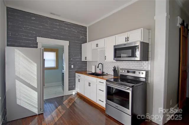 a kitchen with stainless steel appliances a stove microwave and sink