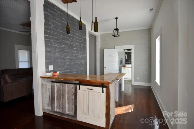 a view of a hallway with furniture and wooden floor