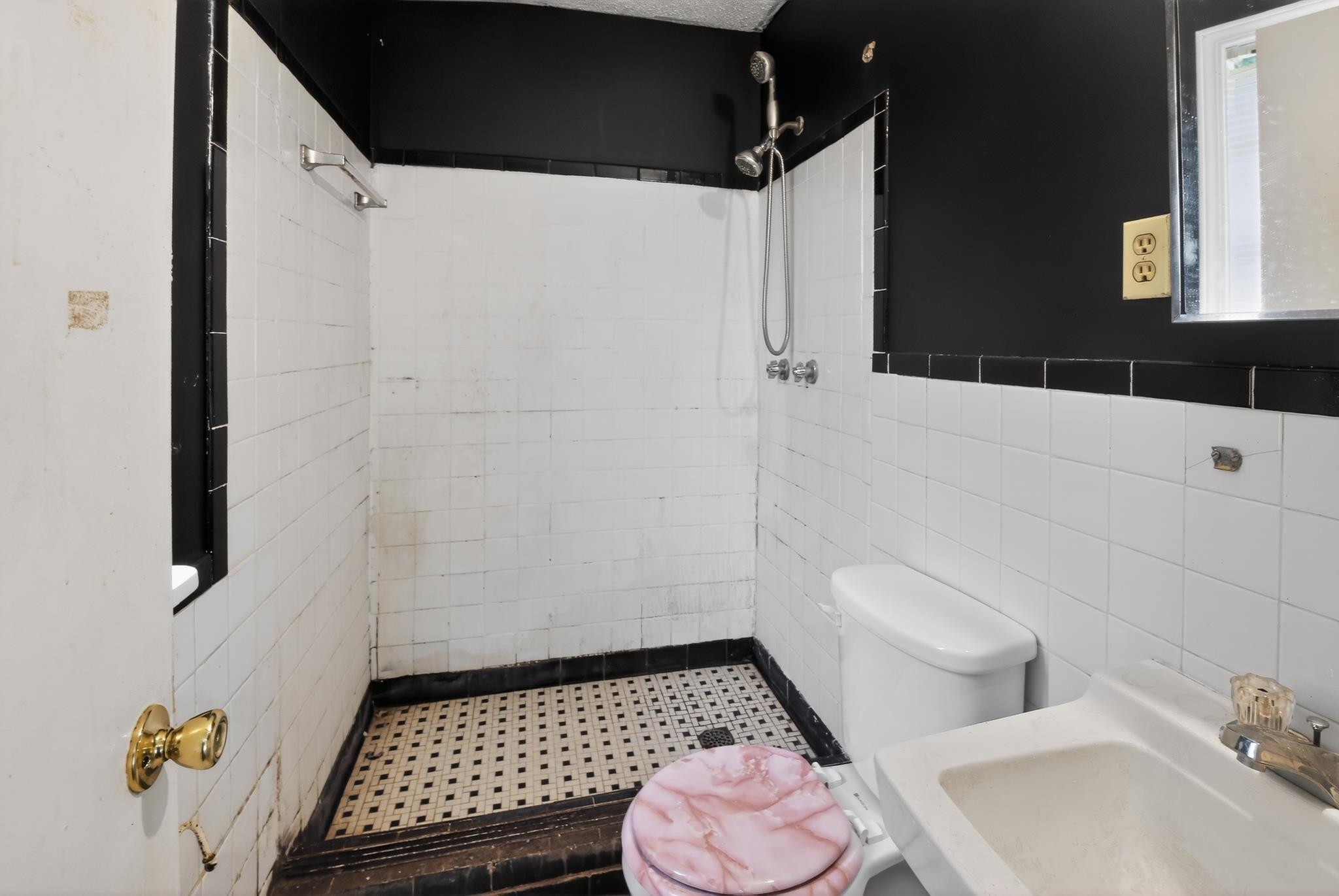 645 Parkrose Road Memphis, TN 38109 - Photo 22 of 32 Bathroom with white tiled walls and black border, featuring a shower area with a black and white mosaic tile floor