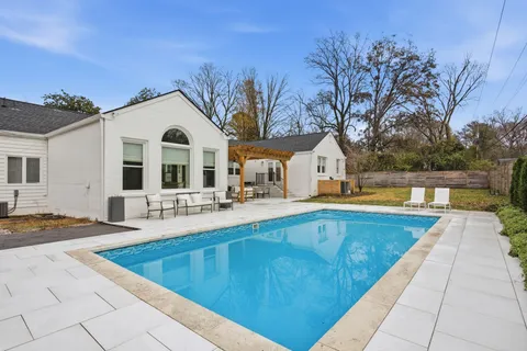 a view of a house with a large pool and a yard