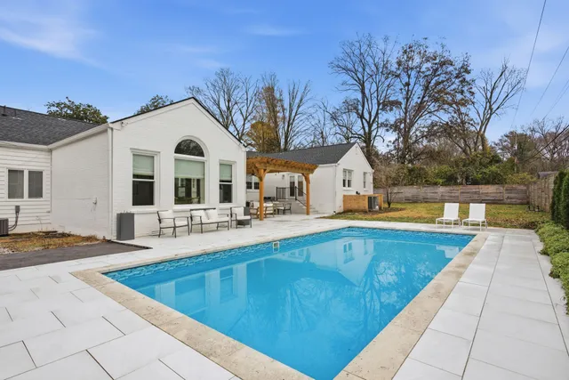 a view of a house with a large pool and a yard