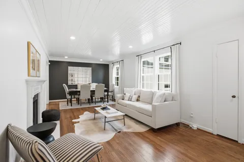 a view of an empty room with wooden floor and windows