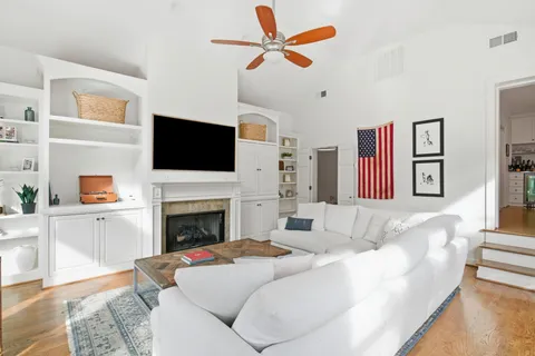 a living room with furniture a fireplace and a flat screen tv