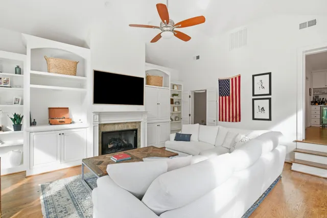 a living room with furniture a fireplace and a flat screen tv