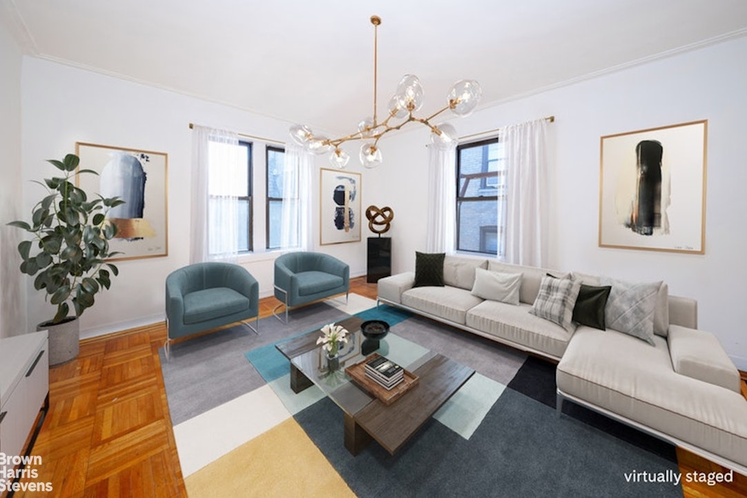 a living room with furniture a chandelier and a rug