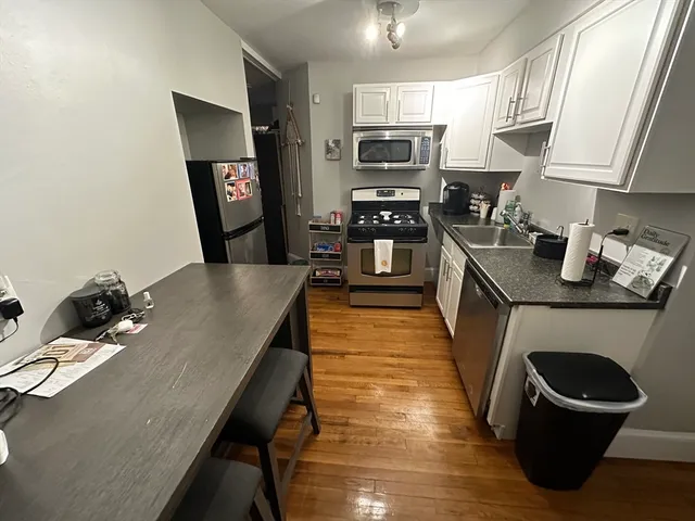 a kitchen with stainless steel appliances granite countertop a sink dishwasher stove refrigerator and microwave