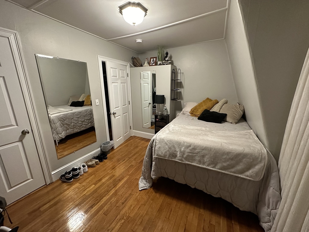 34 Herbert Street, Unit 6 Lynn, MA 01902 - Photo 6 of 9 a bedroom with a bed and a mirror on the dresser