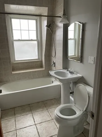 a bathroom with a sink toilet a mirror and bathtub