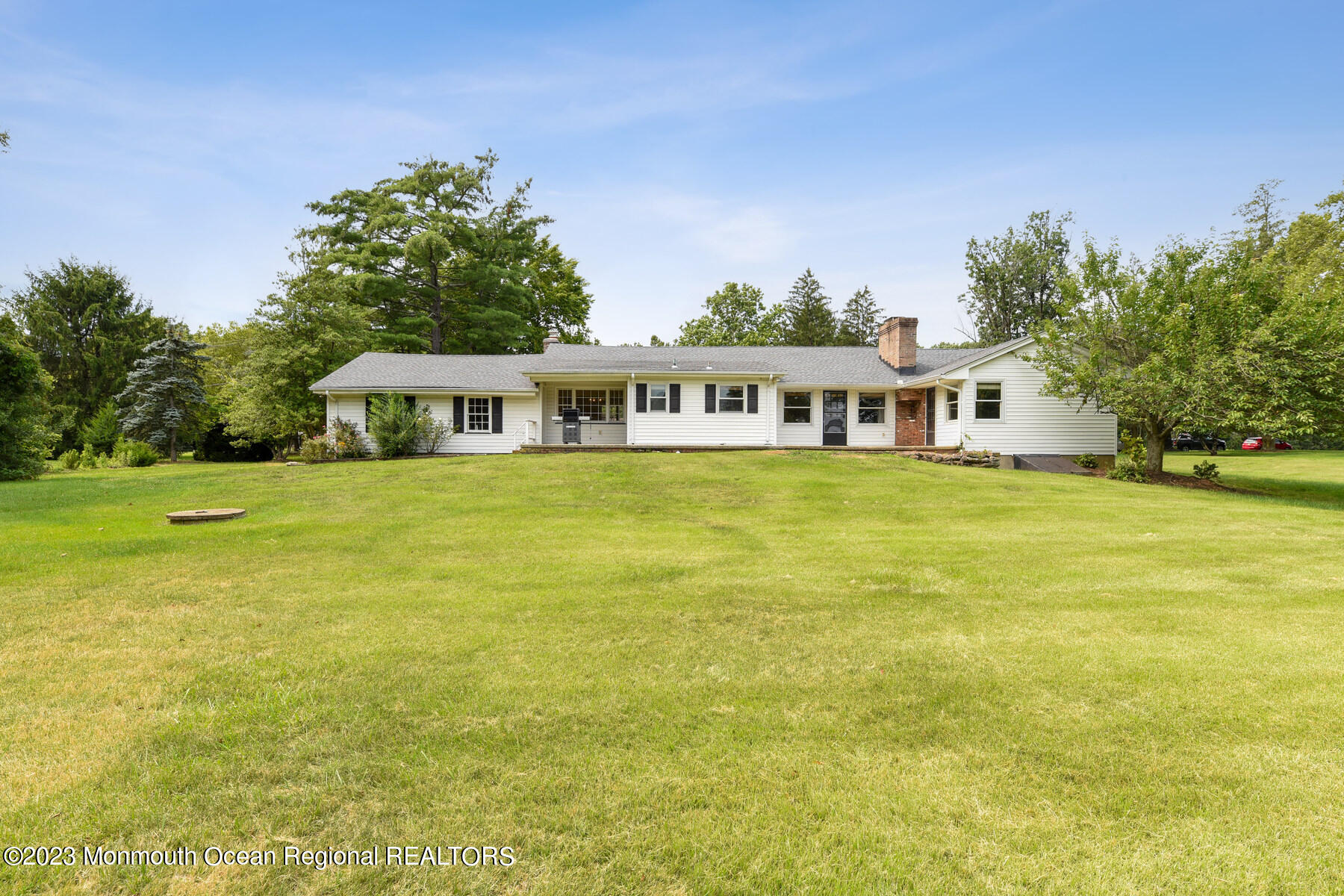 29 Willow Brook Road Holmdel, NJ 07733 - Photo 23 of 35 a view of a blue swimming pool with lawn chairs and large trees