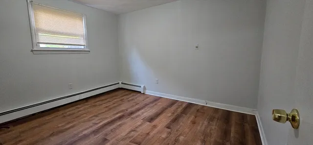 a view of a room with wooden floor and window