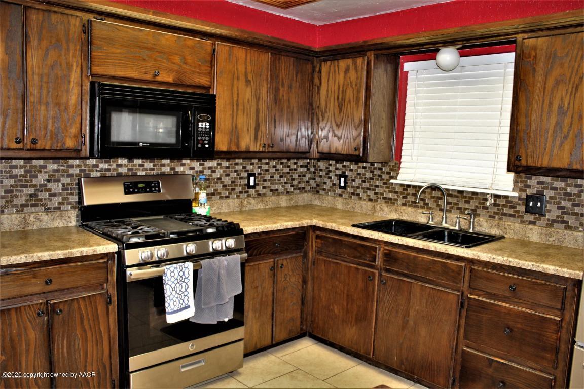 4354 South Polk Street Amarillo, TX 79110 - Photo 8 of 12 a kitchen with granite countertop a stove top oven sink and cabinets