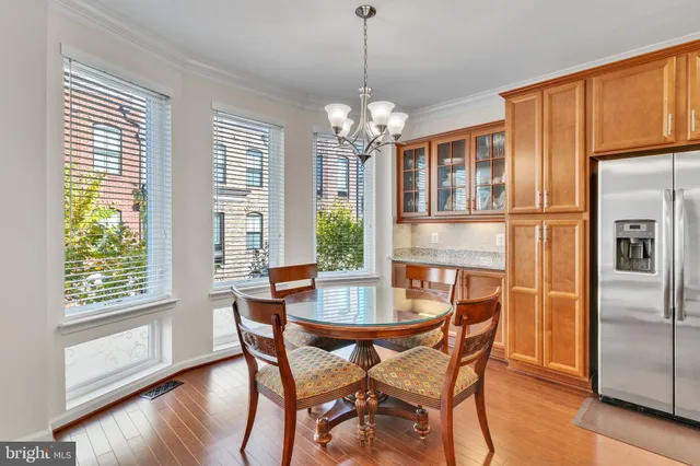 a dining room with furniture a chandelier and wooden floor