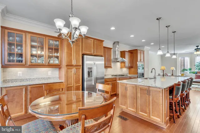 a kitchen with stainless steel appliances granite countertop a sink a stove and a refrigerator