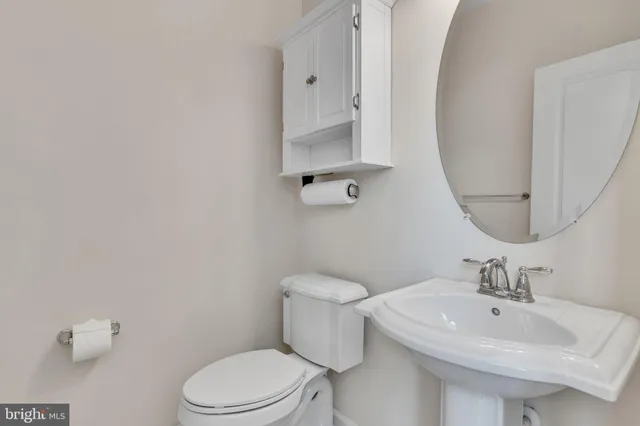 a bathroom with a sink a toilet and mirror