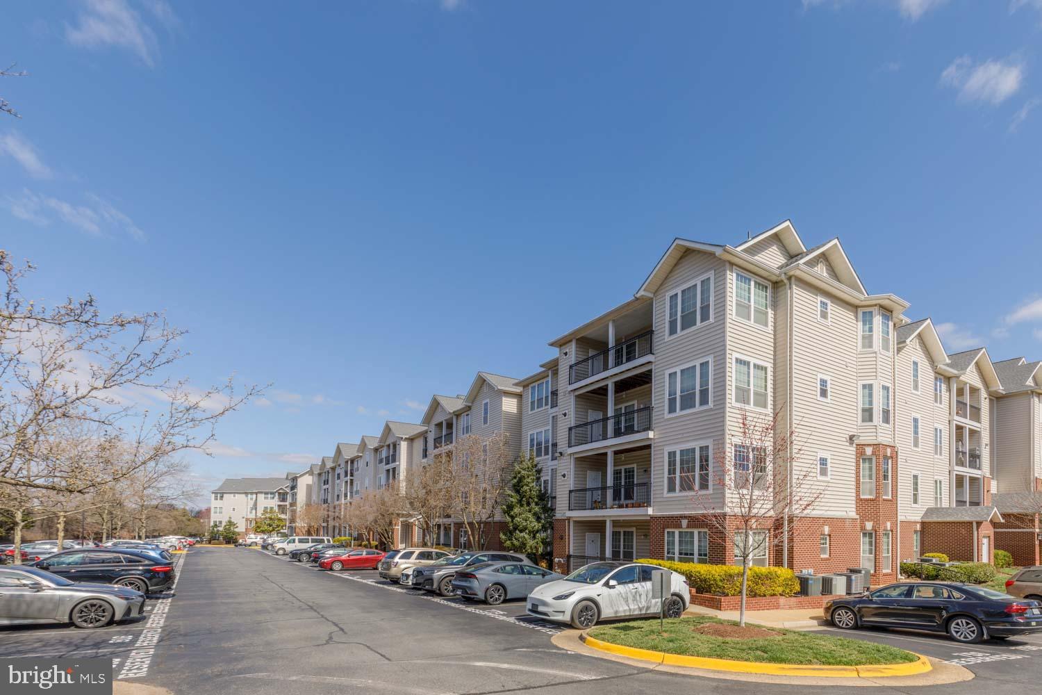 1530 Spring Gate Dr., Unit 9213 McLean, VA 22102 - Photo 19 of 24 a front view of a building with lot of cars and trees